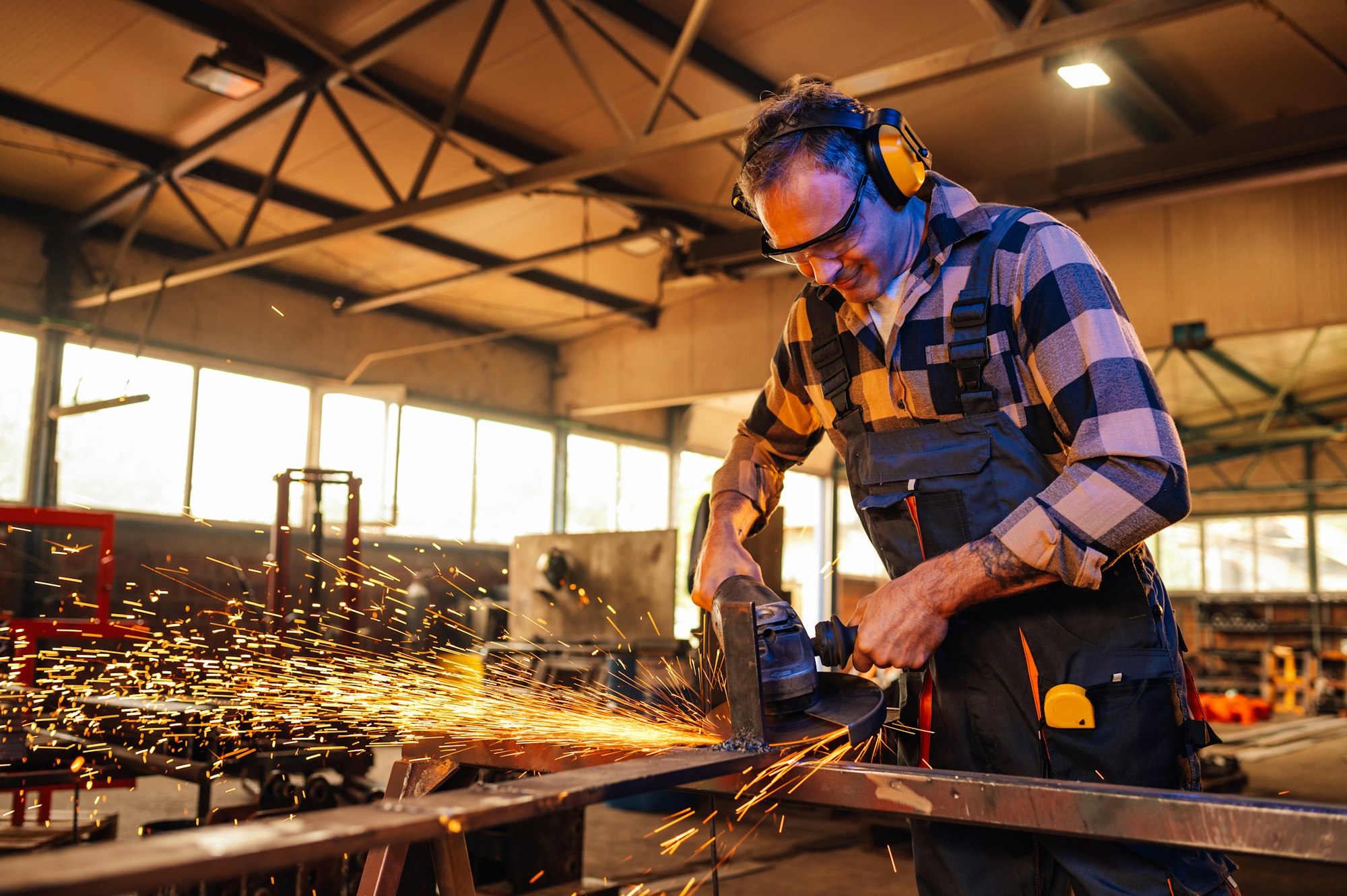 Dedicated worker grinding a piece of metal construction for a project.